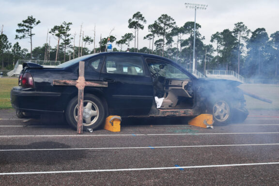 a black wrecked car used in a mock DUI accident event