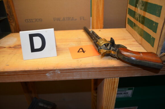 old revolver on table next to evidence markers