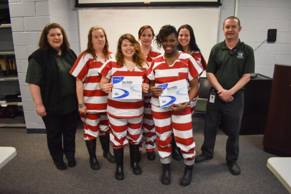 The inmates, which include three women from Escambia County, pose with their certificates.