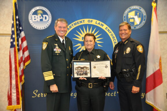 Sergeant Callie Locklear poses with Escambia County Sheriff during Florida Leadership Academy graduation. 