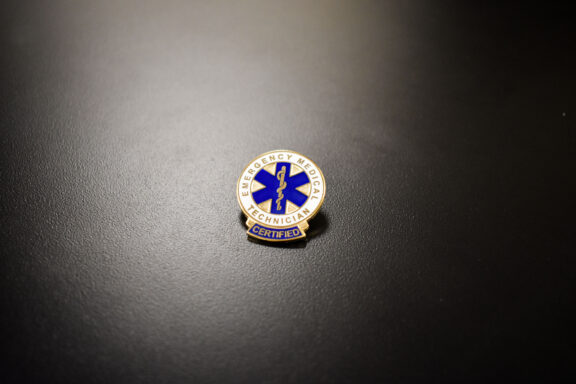 An EMT pin sits on a table at the EMT Graduation Ceremony.