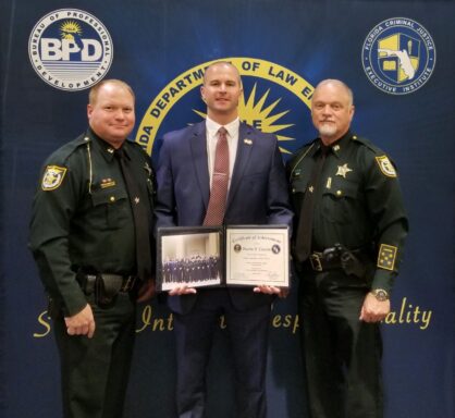 Lieutenant Dustin Cosson poses alongside Captain's Robert Gray and Mark Collins following his graduation from the Florida Leadership Academy. 