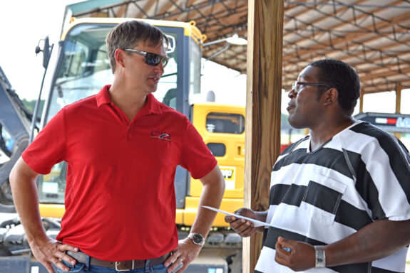 Representative with Local Construction Company Talking to Inmate at Heavy Equipment Graduation Ceremony