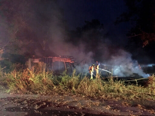 Firefighters spraying water on a home that is on fire