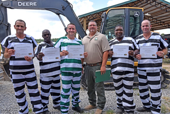 Walton County Jail Inmates Holding Up Certificates of Completion for Heavy Equipment Program