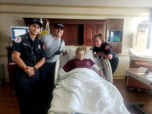 EMTs and Paramedics standing around hospital bed with mother who just had twins