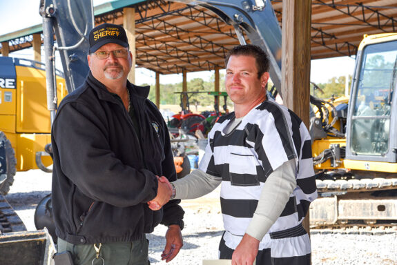 Inmate shaking instructor's hand at Heavy Equipment Graduation Ceremony