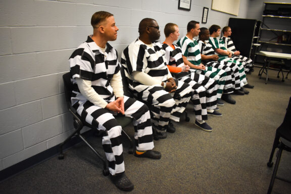 Inmates sit in a classroom at the jail during the welding graduation ceremony.