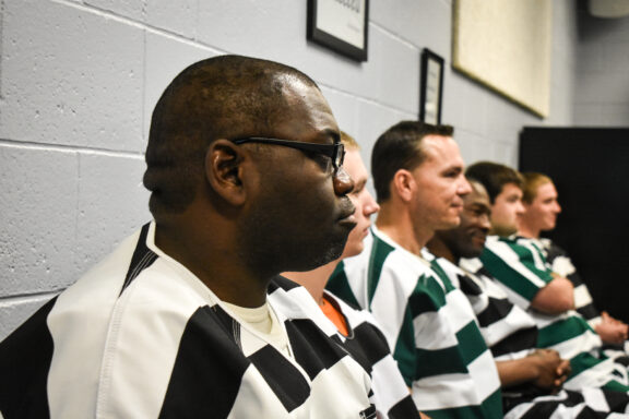 Inmates seated during graduation ceremony.