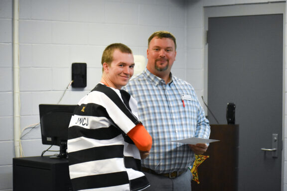 John Greehalgh, Northwest Florida State College welding instructor, smiles with an inmate receiving his certificate.