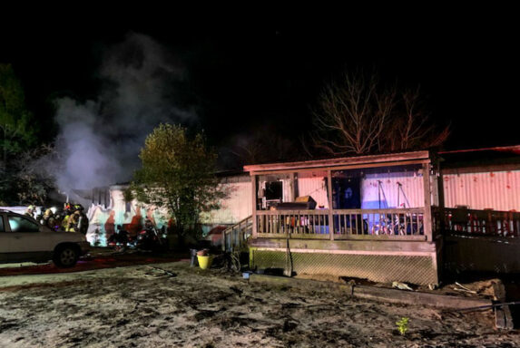 Mobile Home with Smoke Coming From the Left Side of the Home