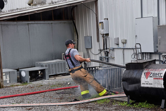 Firefighter with bunker pants on pulling a hose