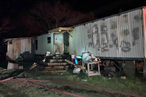 Front of single wide mobile home with damage from structure fire