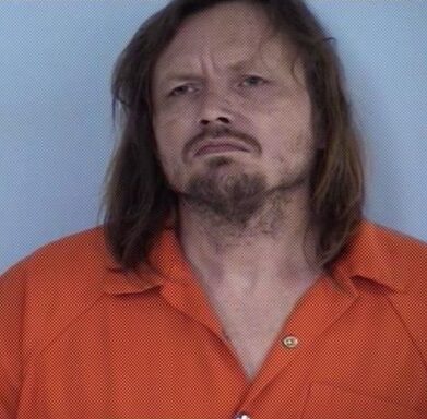 Mug shot of a white male with long hair and a goatee.