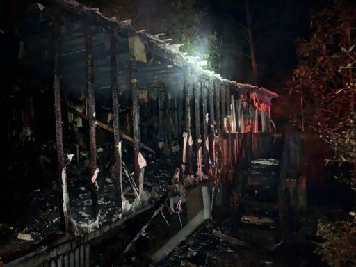 Charred Mobile Home at Night Following a Structure Fire