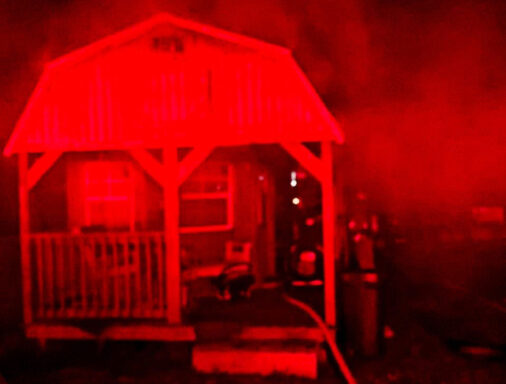 Small residential home with smoke coming from the home in the middle of the night