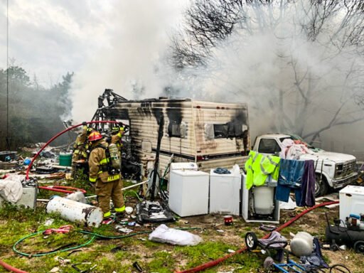 Firefighter working a fire that broke out in a fifth wheel camper