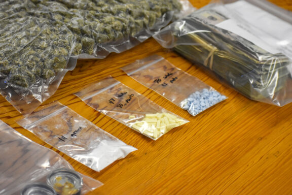 Three plastic bags with cocaine and pills inside. 