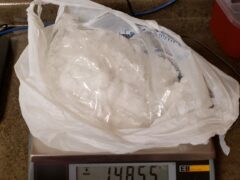a white plastic bag full of a white powdery substance on a scale than reads more than 1400 grams.