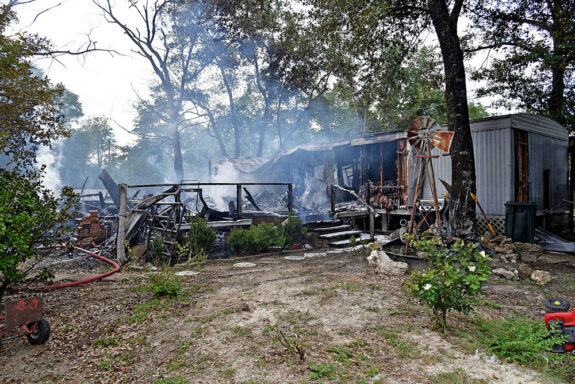 Damaged mobile home with smoke coming out of it