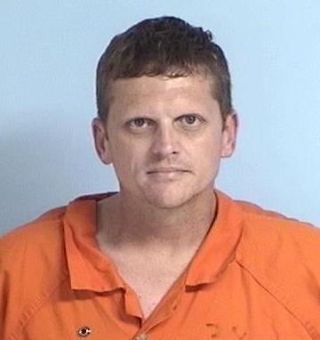 Mug shot of a white male wearing an orange jump suit.