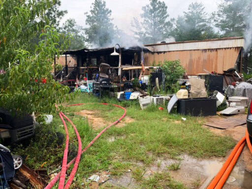 Single wide mobile home with smoke coming from inside the home