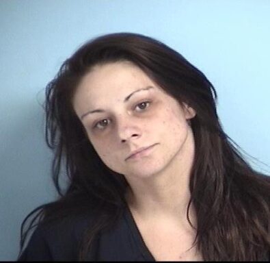 Mug shot of a wehite female with brown hair in a navy blue jumpsuit.