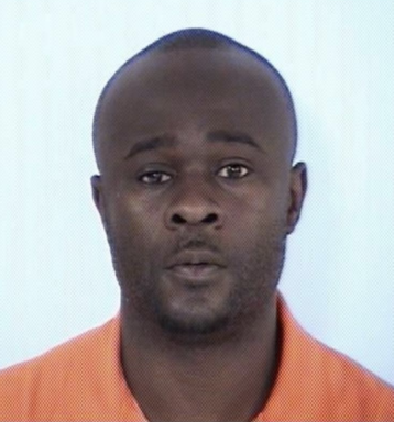 Mug shot of black male with brown eyes wearing an orange jumpsuit