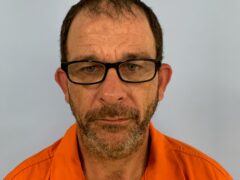 Mug shot of a white male with black glasses