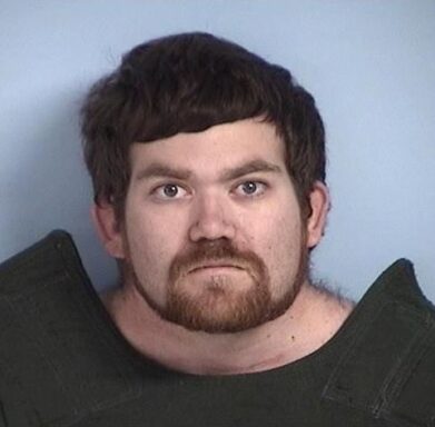 Mug shot of white male with dark hair and a beard.