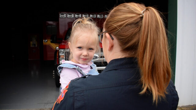 Child being carried by a paramedic.