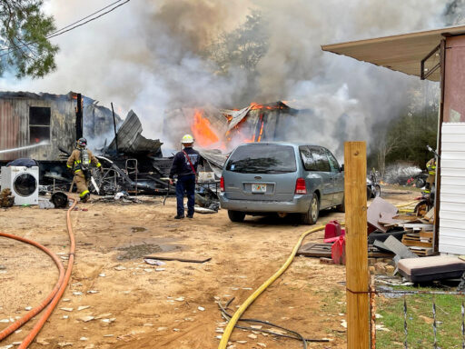 Firefighters in front of burning mobile home