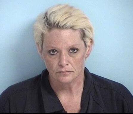 Mug shot of white woman with dyed blonde hair and dark roots
