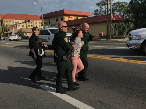 Deputies escorting woman in handcuffs.