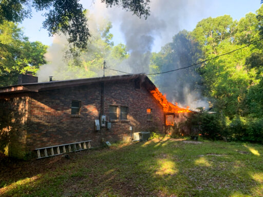 Flames coming from the back of a brick single-story home