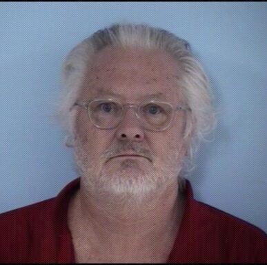 Mugshot of white male wearing clear rimmed glasses with white hair