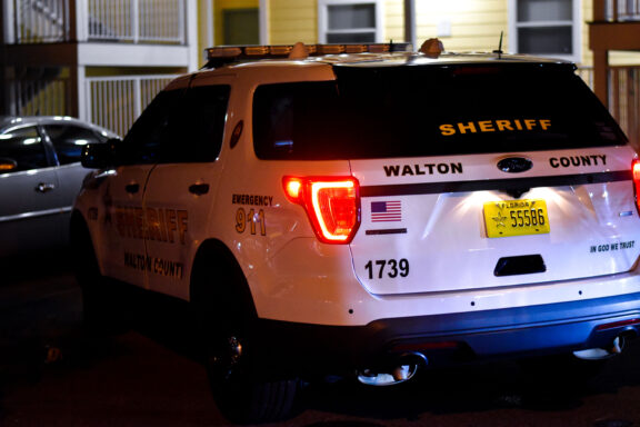 A patrol car parking in front of crime scene tape
