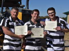 three inmates holding certificates