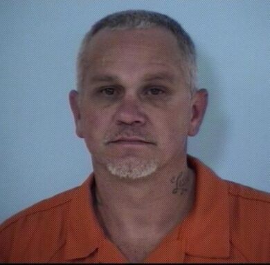 Mug shot of a white male with white hair and a white and gray goatee