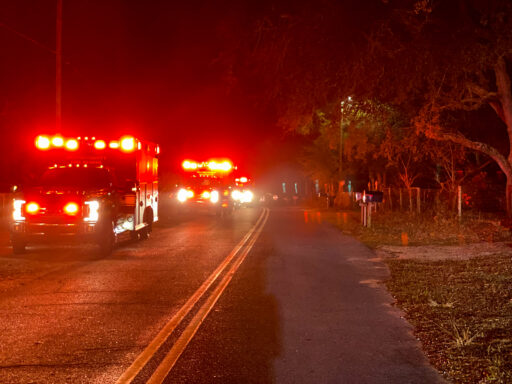 Ambulances and fire trucks lined up in the street with lights on