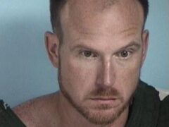 mug shot of a white male in a green jumpsuit