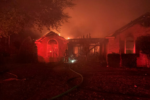 Flames coming from a single-story brick home