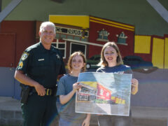 Sergeant Mark Wendel pictures with artist Kaylie Finch and art teacher Ms. Dotson