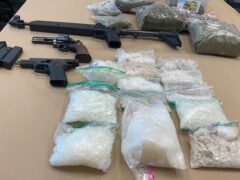 meth and marijuana on a table with a rifle and two pistols