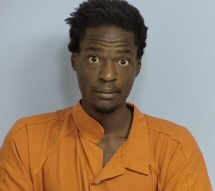 Mug shot of black male with short hair and a goatee wearing an orange jumpsuit.