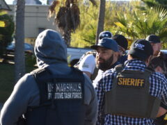 U.S. Marshals and Sheriff Deputies arresting a hispanic male wearing a ball cap