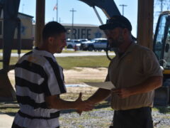 An inmate shakes the hand of the vocational instructor at the Walton County Jail