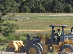An inmate drives a front end loader across the Walton County Jail farm