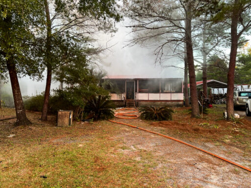 Smoke coming from a white and red mobile home