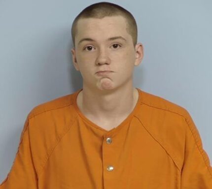 Mug shot of a white teenager with a buzz cut and brown eyes. 